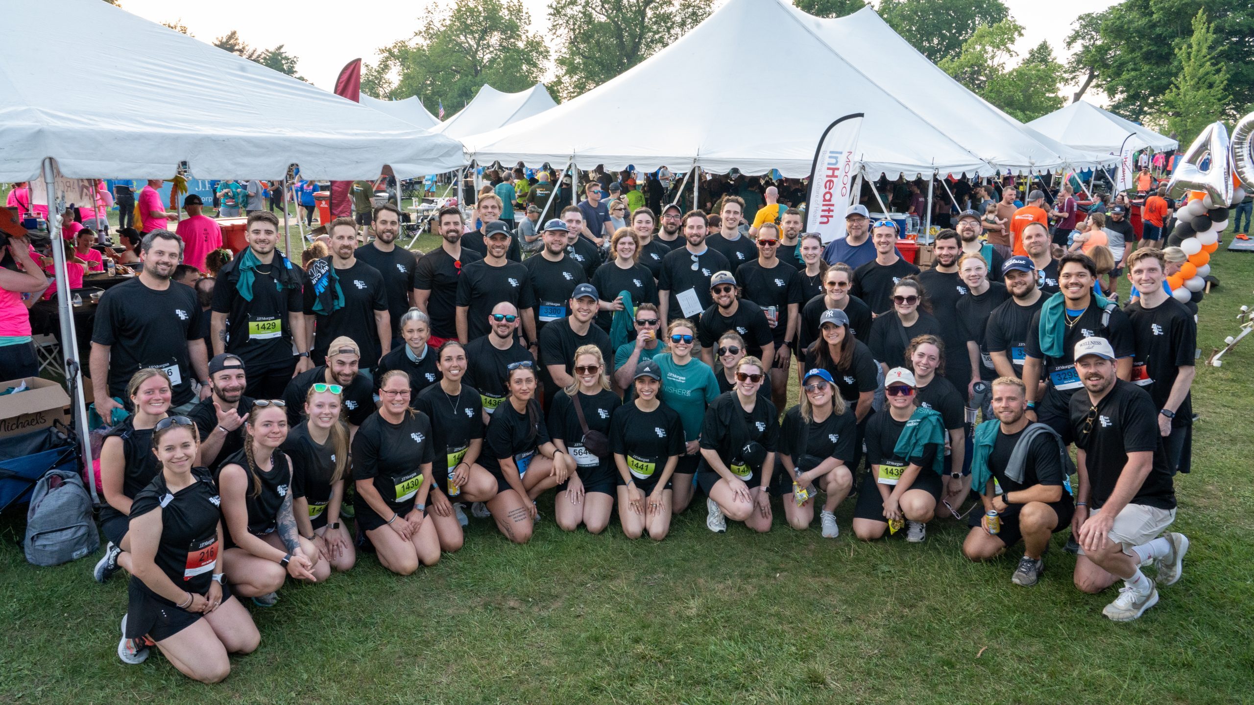 Teammates from Buffalo Rehab Group posing for a photo smiling in black team t-shirts at the 2025 JP Morgan Corporate Challenge.