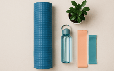 Flat lay of a rolled yoga mat, small plant, water bottle, and resistance bands on a light background representing calm, balanced recovery.
