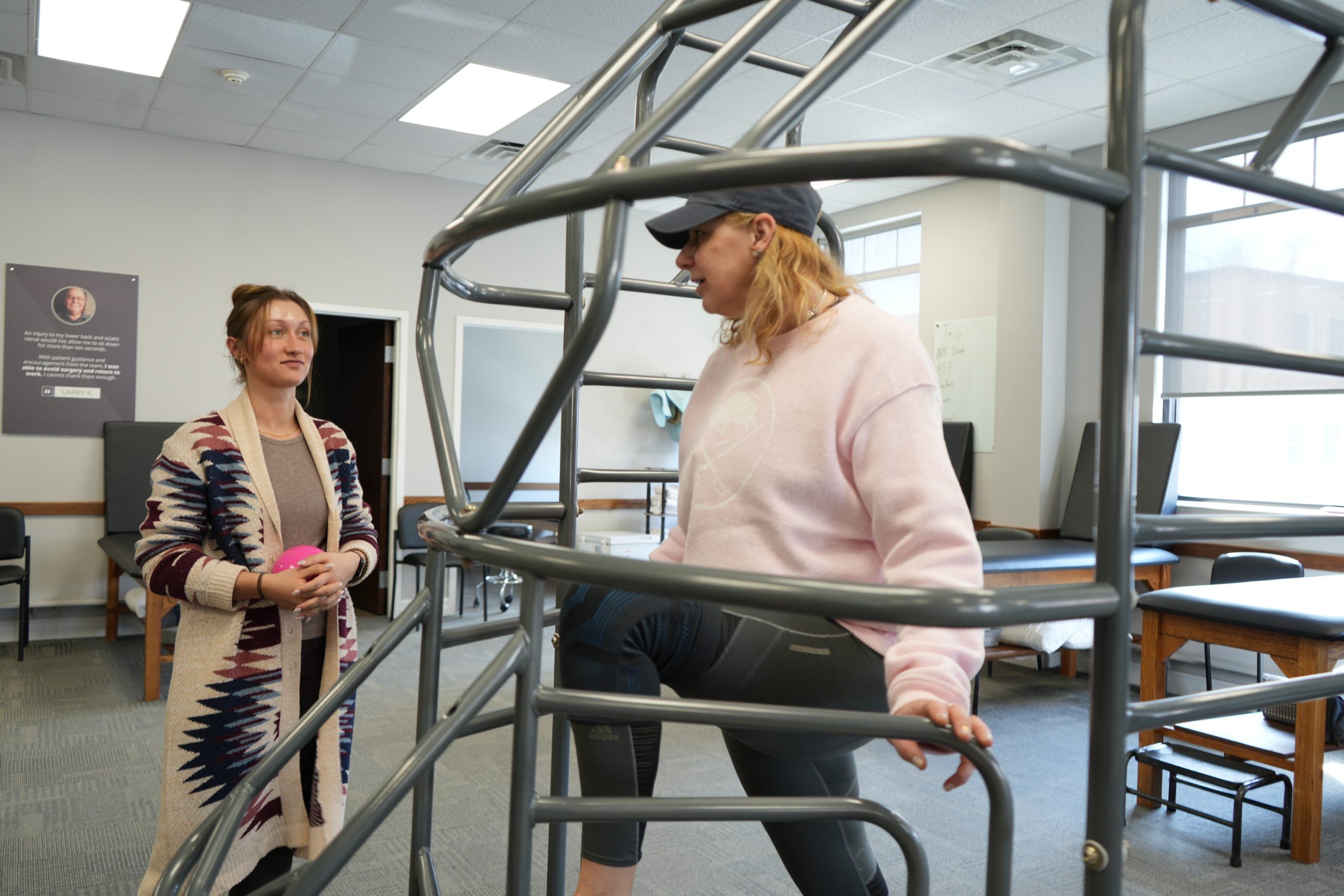 BRG patient Jill, doing a cage stretch talking with her Physical Therapist Assistant, Ali Hartman, PTA. 