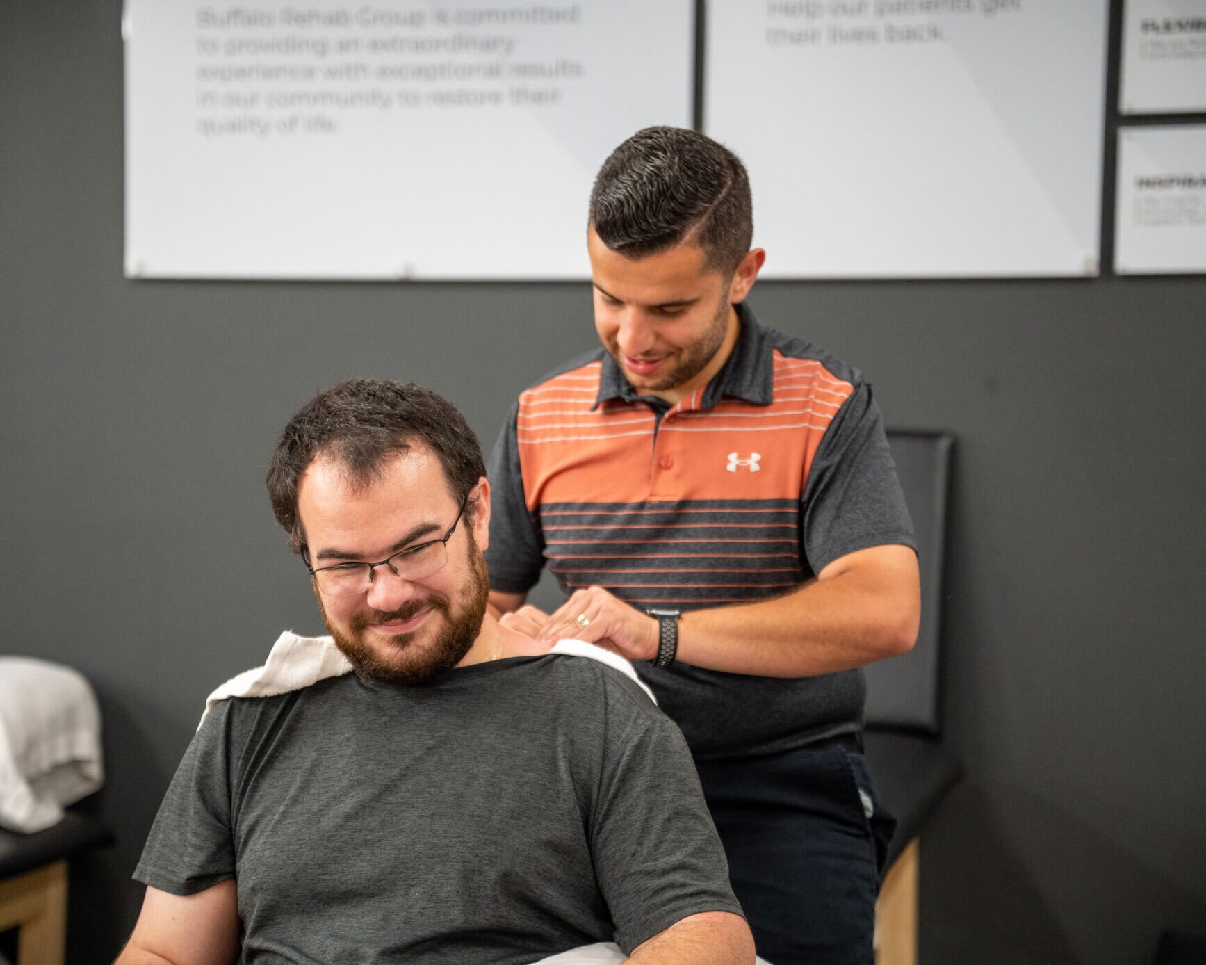 A Physical Therapist happily works on a head & neck patient.
