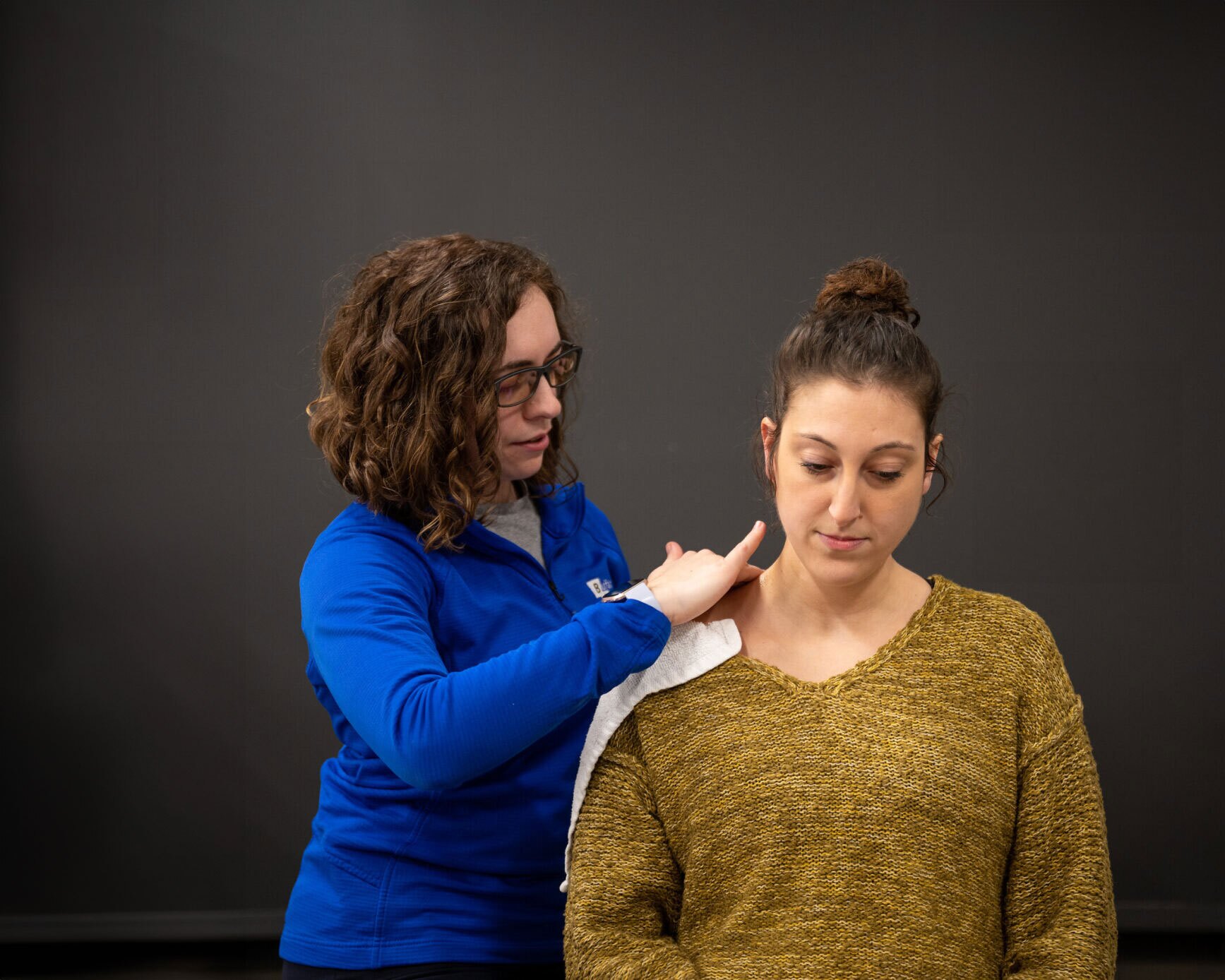 A Physical Therapist happily works on a head & neck patient.