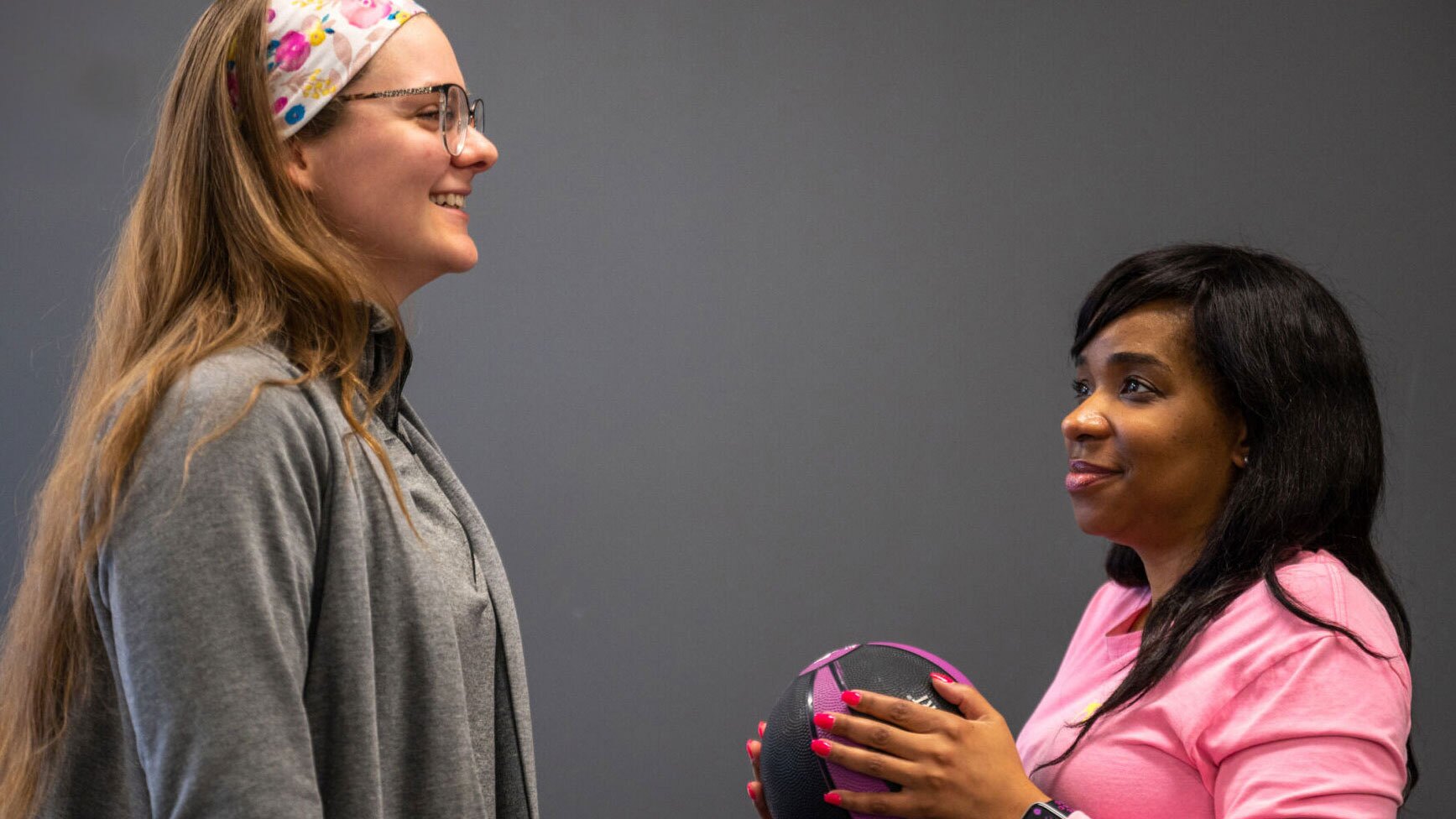 A Physical Therapist happily talking to a shoulder patient
