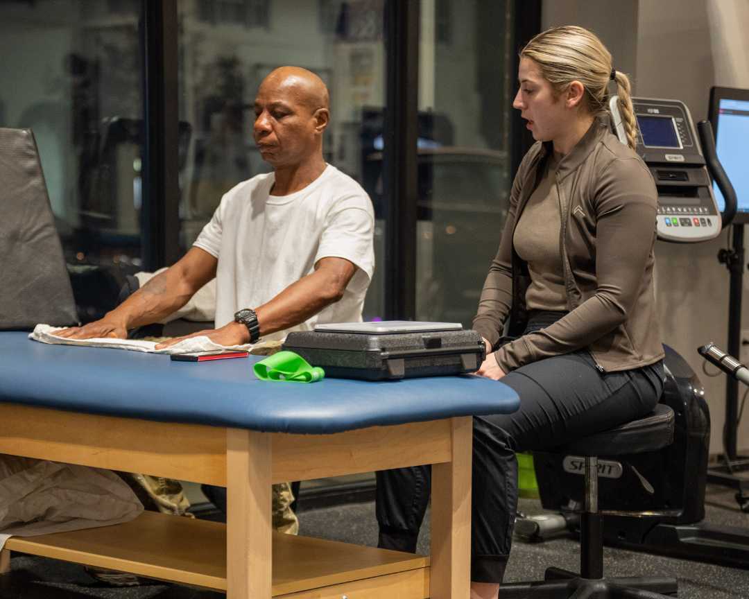 An Occupational Therapist smiles as she treats her patient.
