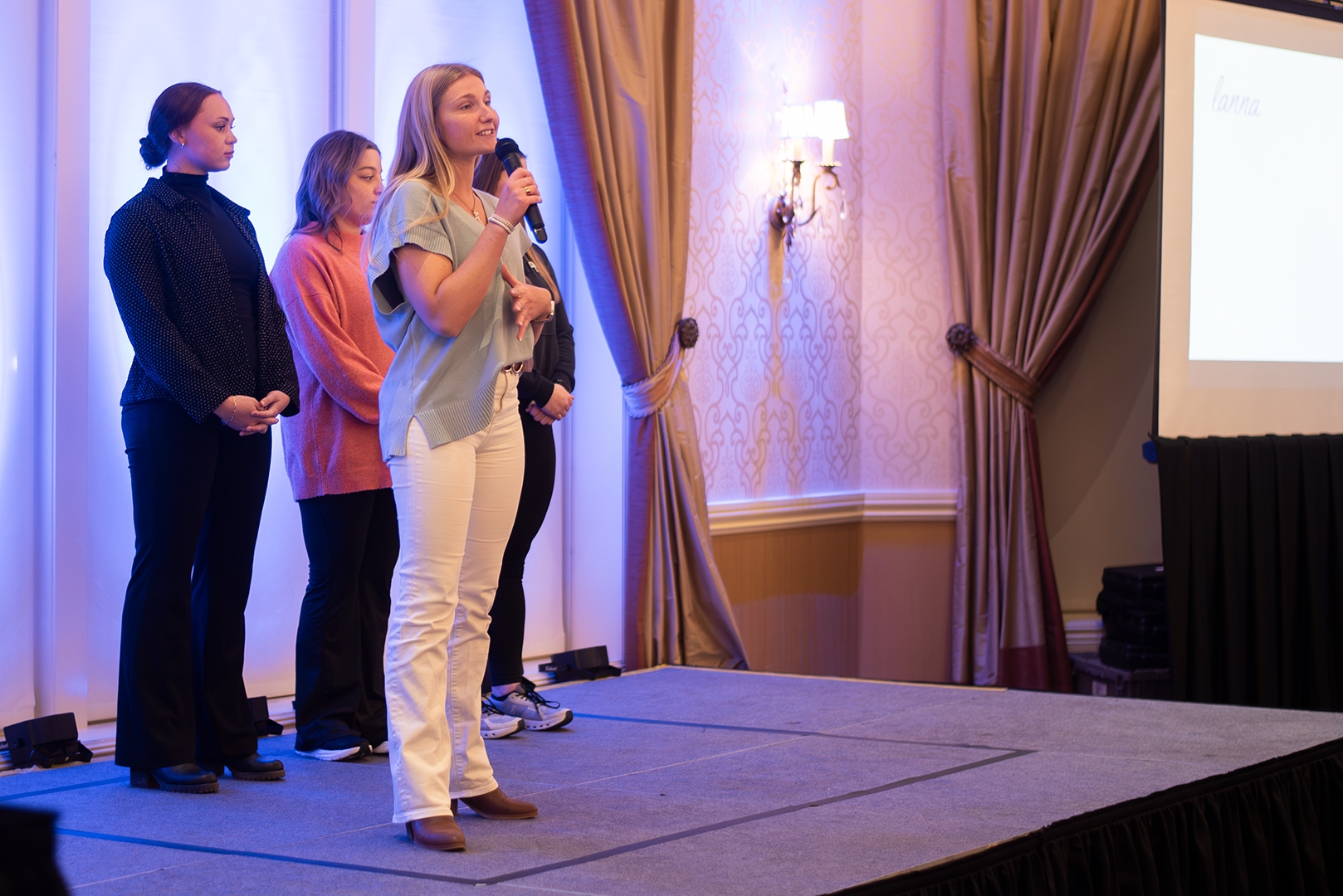 Image of Alexa Lukaszonas, a member of our Patient Experience team, standing on stage, speaking at the BRG 2025 Annual Meeting.