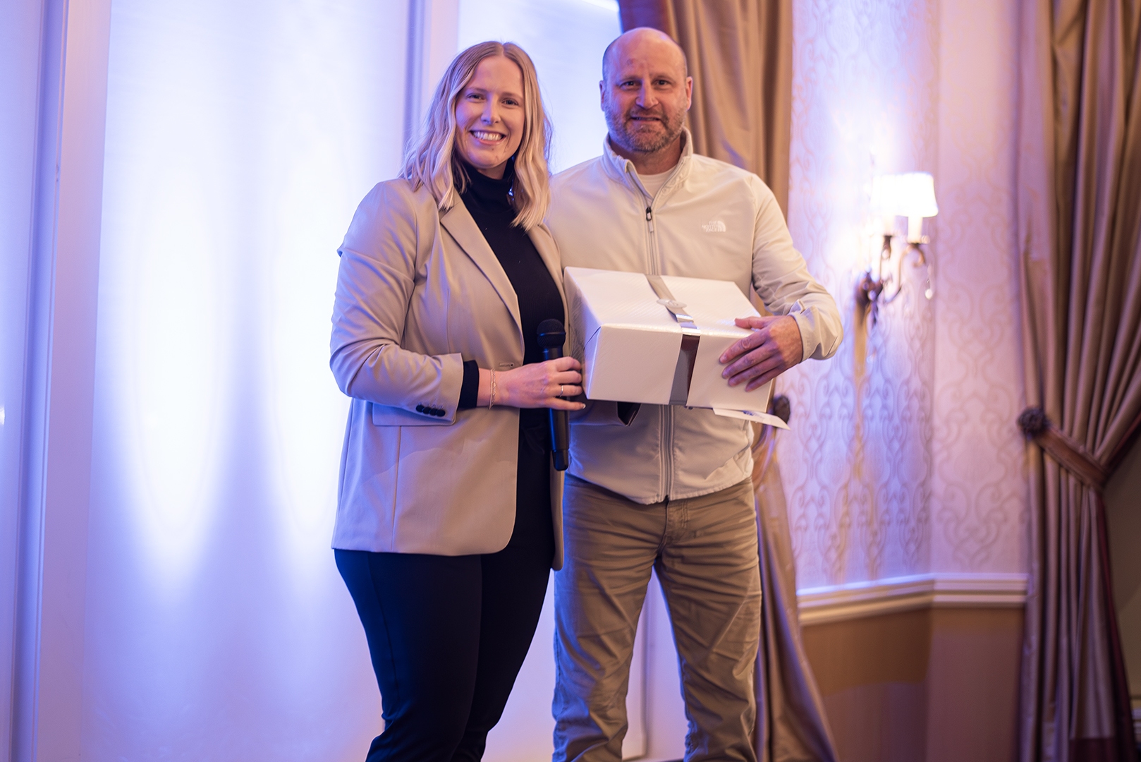 Image of Hannah Buffa, Leader of Learning and Development with Chris Woodrich, Facilities as he accepts his award as the 2025 BRG Best in Buffalo winner.
