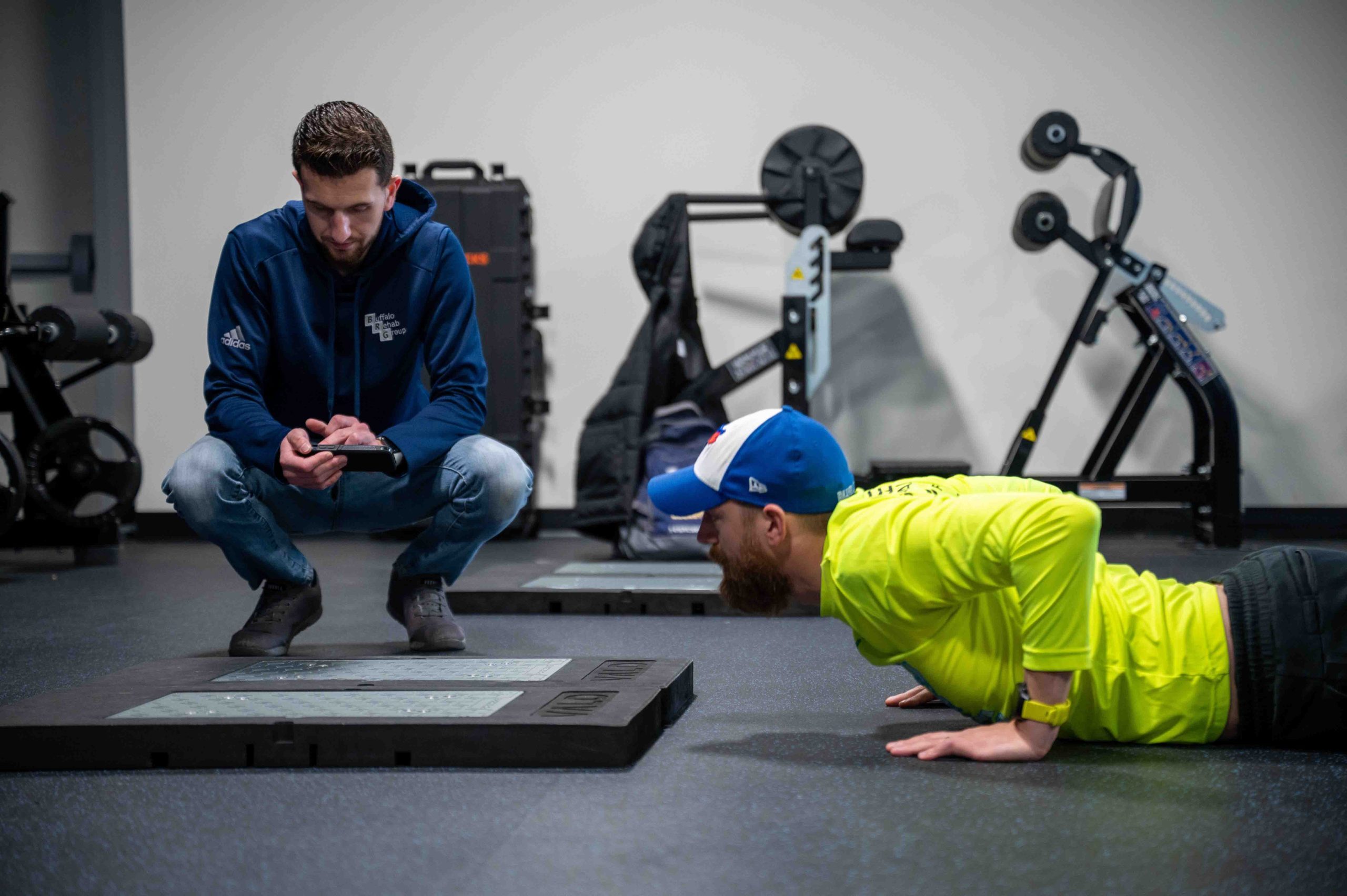 A physical therapist smiles as he converses with his patient.