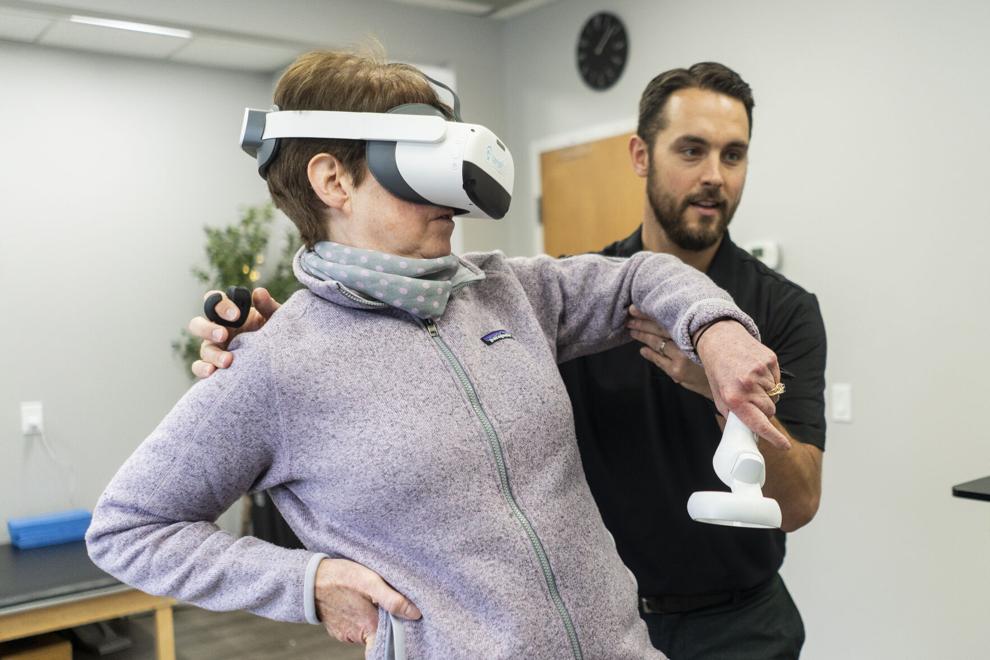 An image of a women wearing an interactive headset and a therapist helping her
